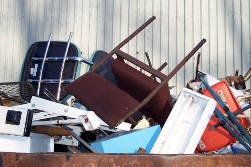 Two-person crew loading a van with green waste in a Southfields back garden